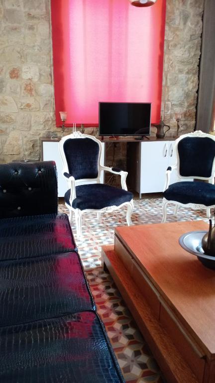 a living room with two chairs and a tv at Khalle lodge in Dayr al Qamar