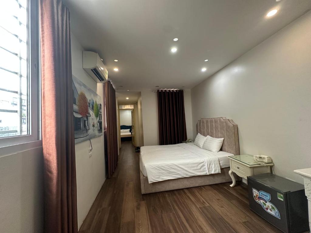 a small bedroom with a bed and a window at Hanoi Better Hotel & spa in Hanoi
