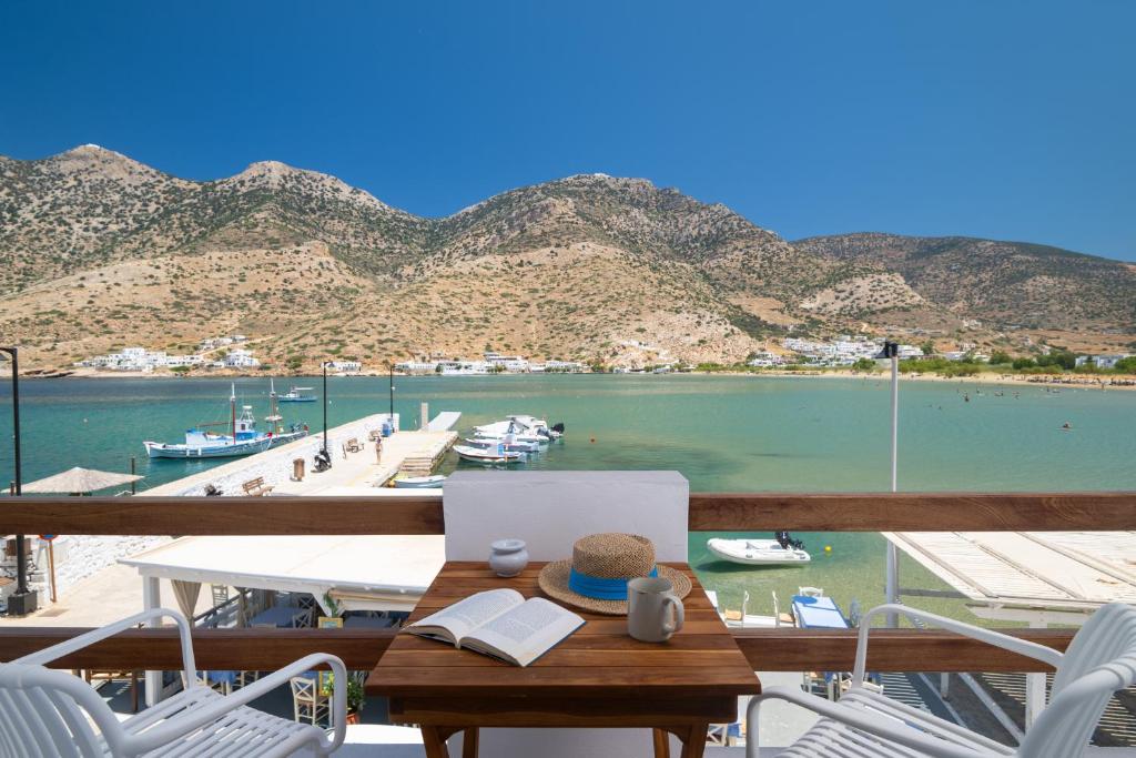 a table and chairs with a view of a marina at Aurum Suites Sifnos in Kamares
