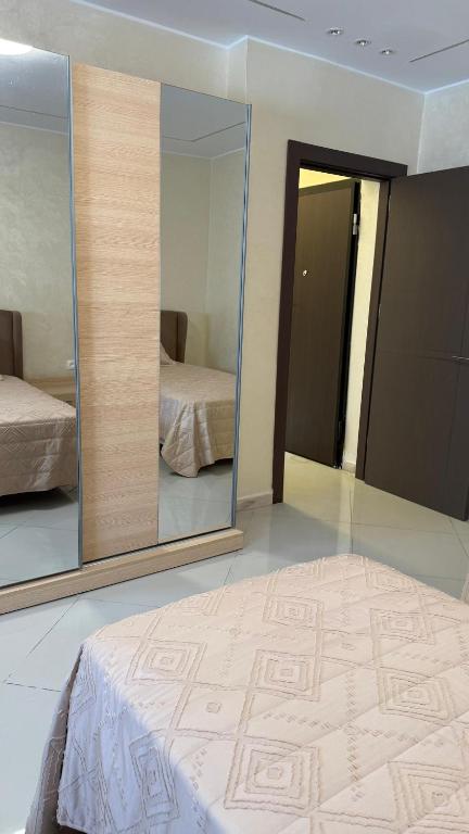 a bedroom with a large mirror and a bed at إقامة الرمال الذهبية in Les Hamiane
