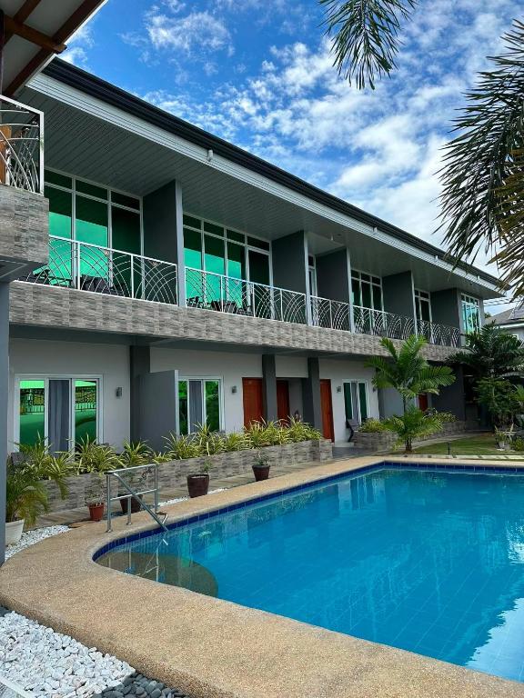 a house with a swimming pool in front of it at Green Field Resort Hotel in Anda