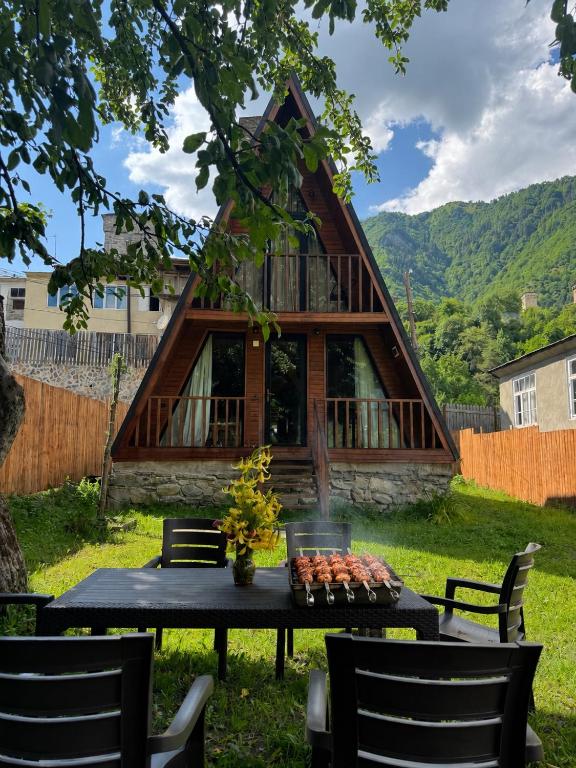 a house with a table and chairs in a yard at Cozy Cottage JuFu in Mestia