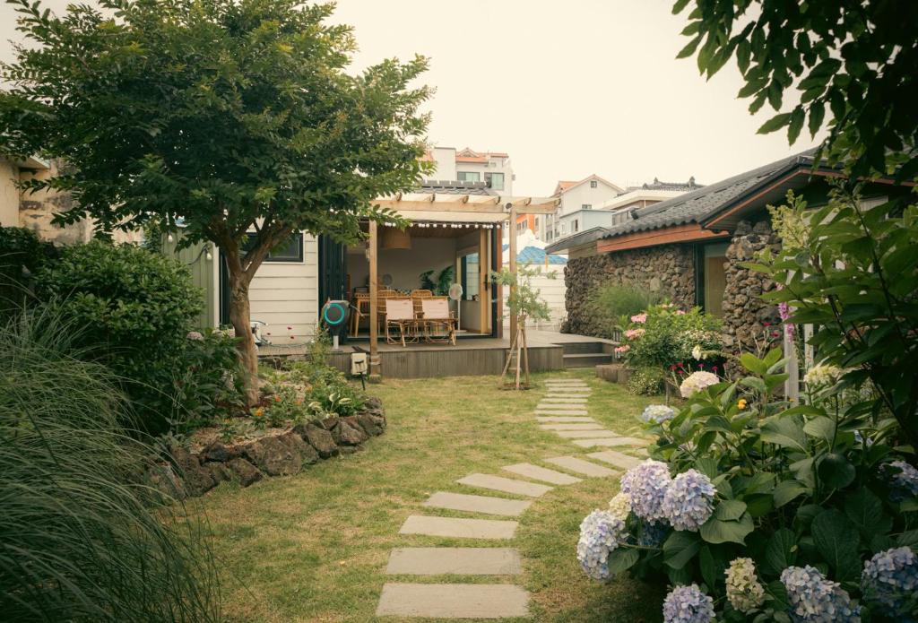 a garden with a stone path leading to a house at 스테이 모슬 in Daejeong