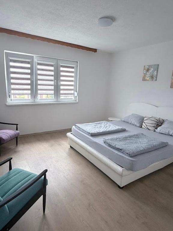 a bedroom with two beds and a couch and two windows at Sweet Home in Tuzla