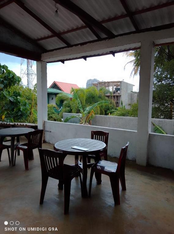a patio with two tables and chairs and a table and benches at Rithu Homestay in Sigiriya