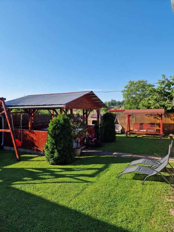 a yard with a gazebo and a chair in the grass at Casa Rodica Turda in Turda