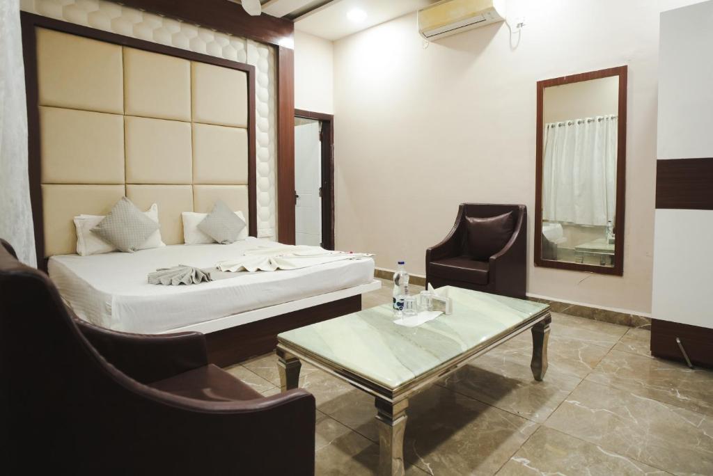 a bedroom with a bed and a table and chairs at K2 Highway Treat & Resort Unit of Lyzon in Bhadaura