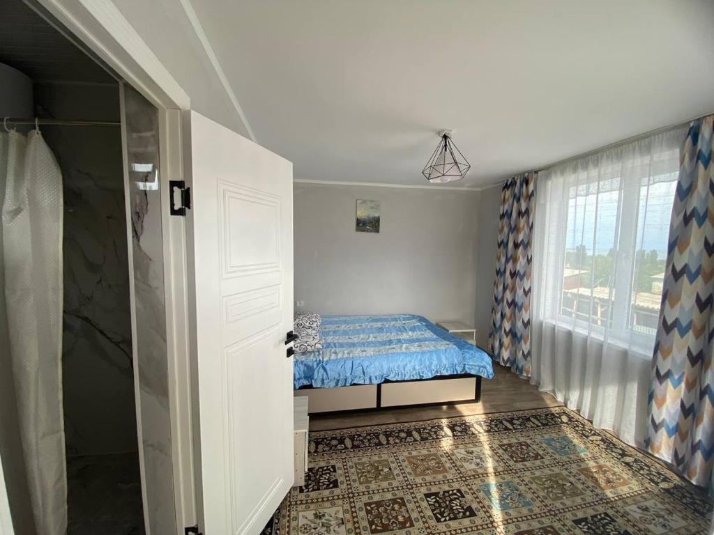 a small bedroom with a bed and a window at Гостевой дом Амир с Корумду in Korumdy