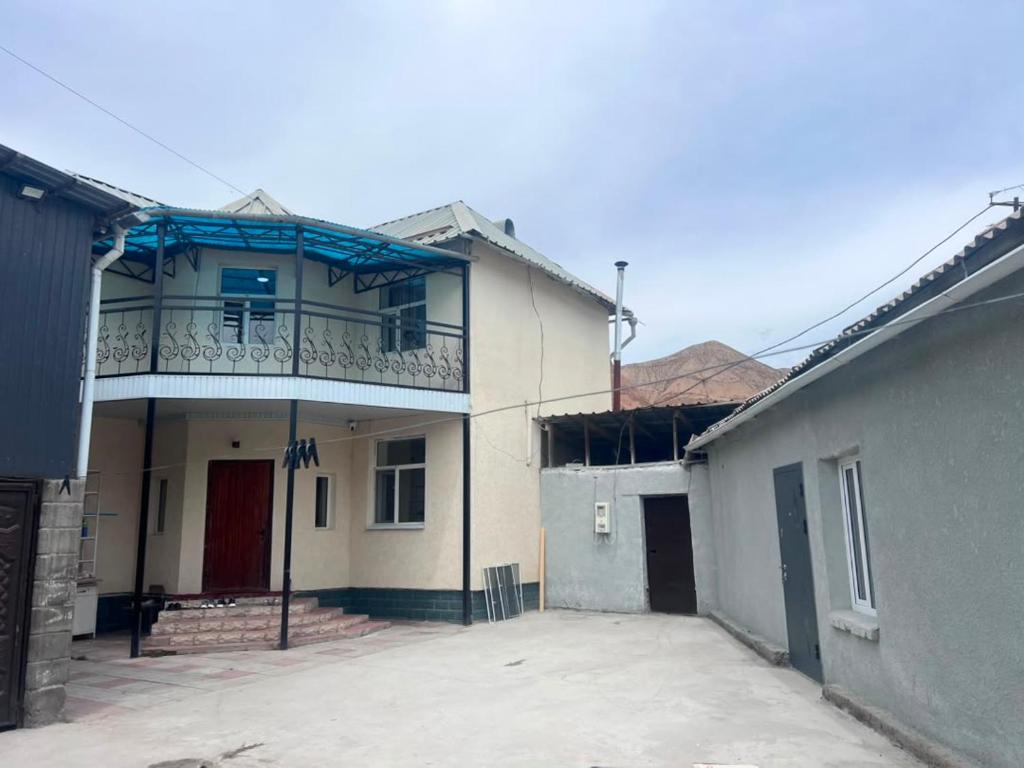 a building with a balcony on top of it at Terme Guesthouse in Naryn