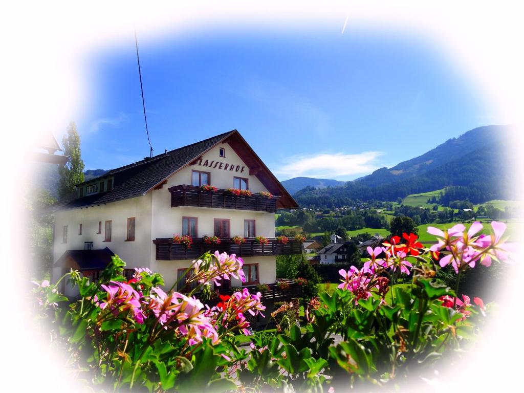 a white house with flowers in front of it at Lasserhof in Aigen im Ennstal