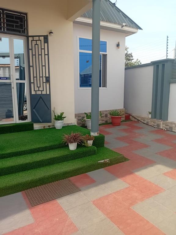 a house with a green lawn in front of it at Nelca Executive Lodge in Mwanza