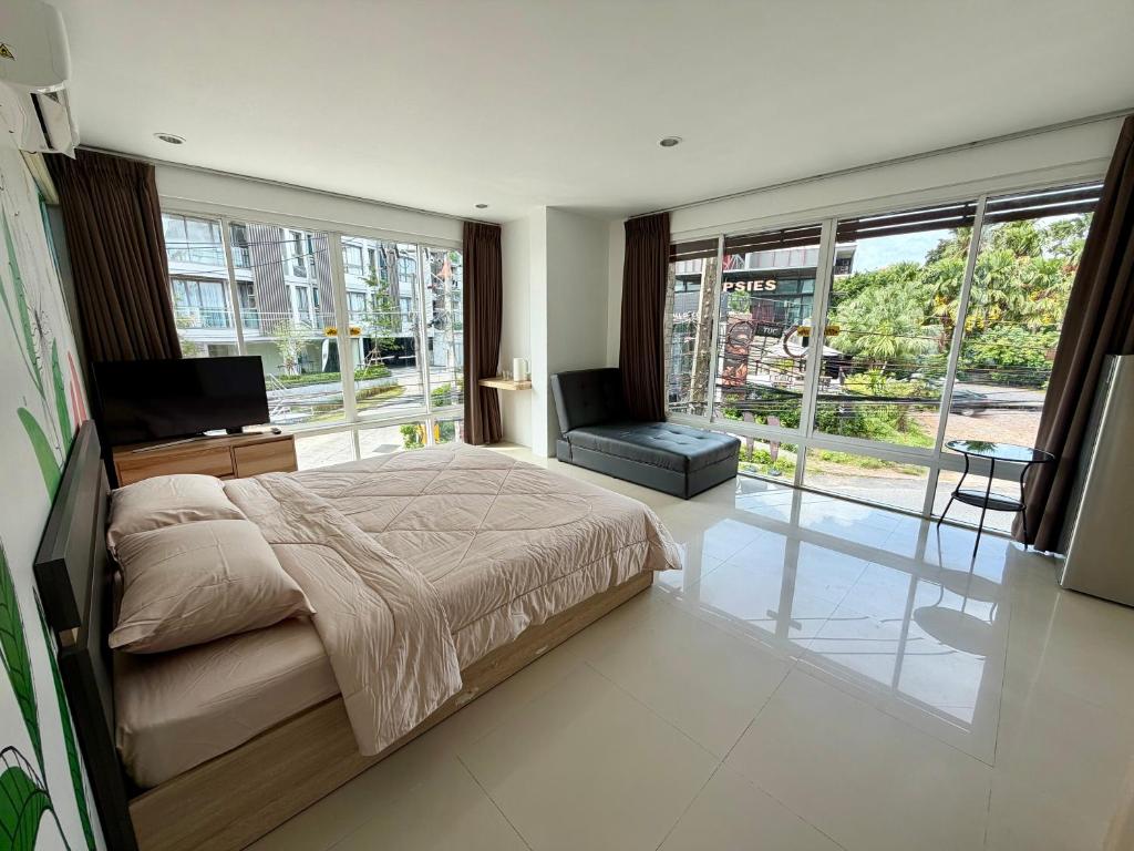a bedroom with a bed and a large window at The CHU cafe / guesthouse in Nai Harn Beach