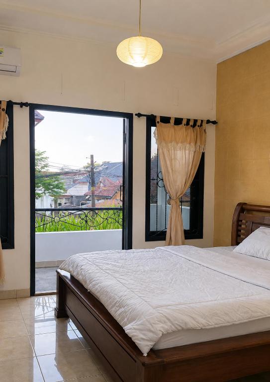 a bedroom with a large bed and a large window at Ambarosed Homestay in Ngaglik