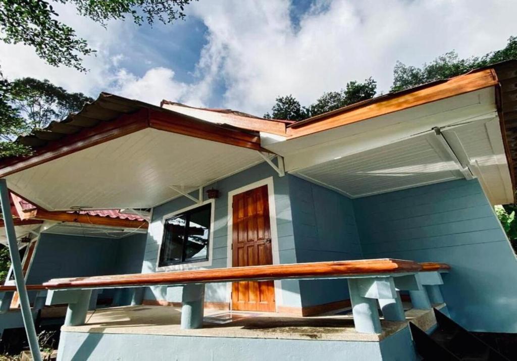 a small blue house with a porch at Villa Beside Swiming Pool With Garden View in Ban Map Khangkhao