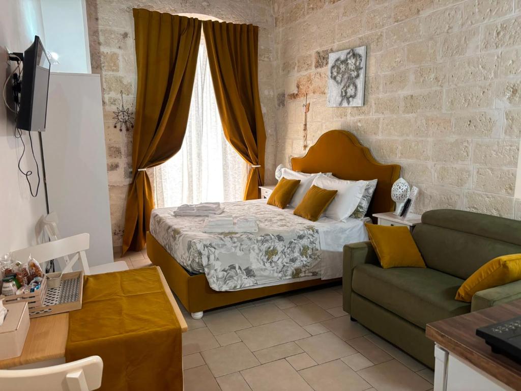 a bedroom with a bed and a couch at Casa Nave in Monopoli