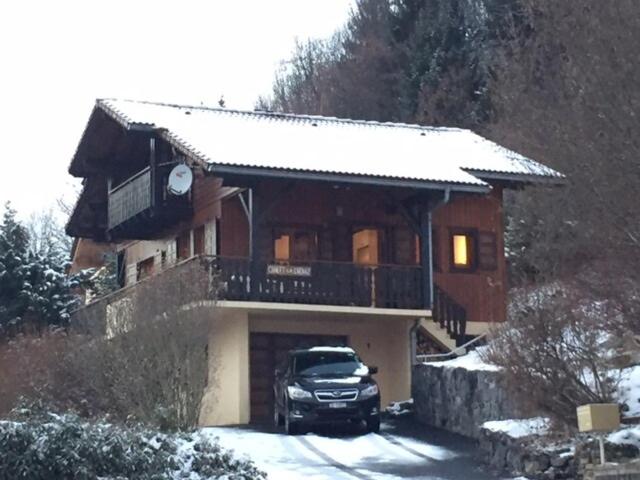a car parked in front of a house in the snow at Comfortable Chalet with spectacular mountain views in Verchaix