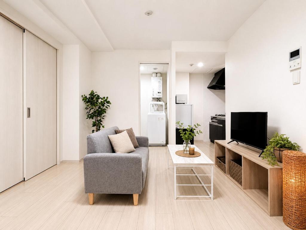 a living room with a chair and a tv at Glory 豊平 -FIX HOME- in Sapporo