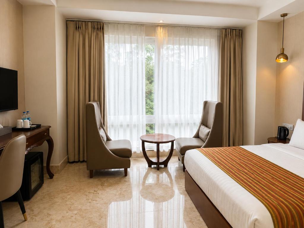 a hotel room with a bed and a desk and a window at Lotus Villa in Phuntsholing