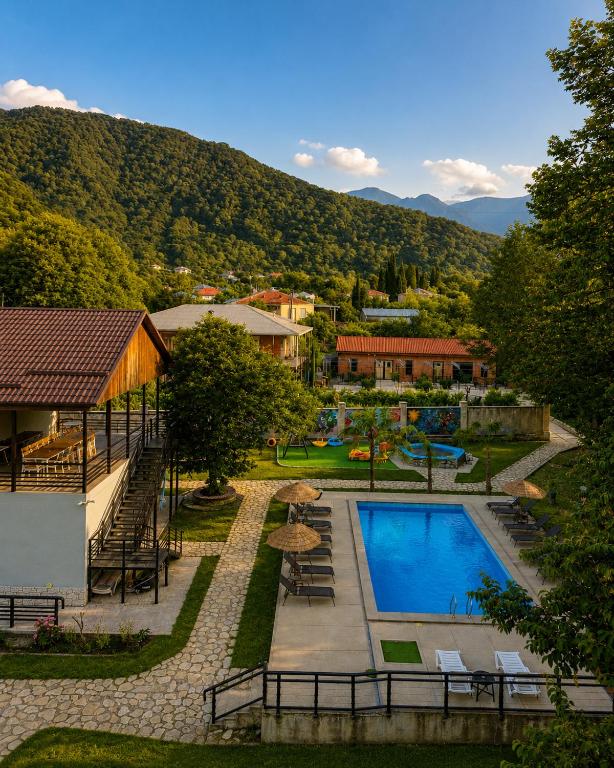 a resort with a swimming pool and mountains in the background at Arazani in Lagodekhi