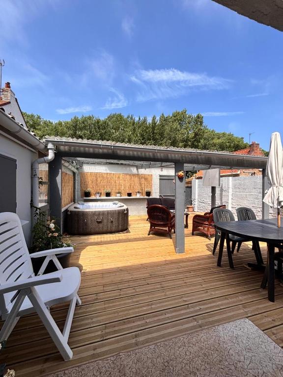 a wooden deck with a table and chairs at La maison de mamy in Bray-Dunes