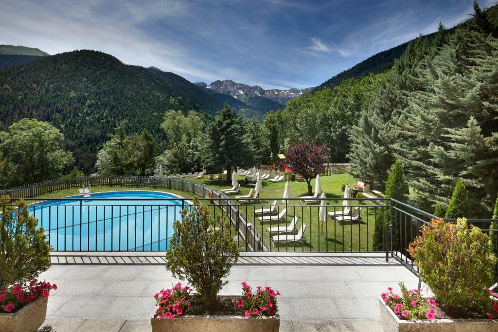 a resort with a pool and mountains in the background at Parador de Vielha Spa & Wellness in Vielha