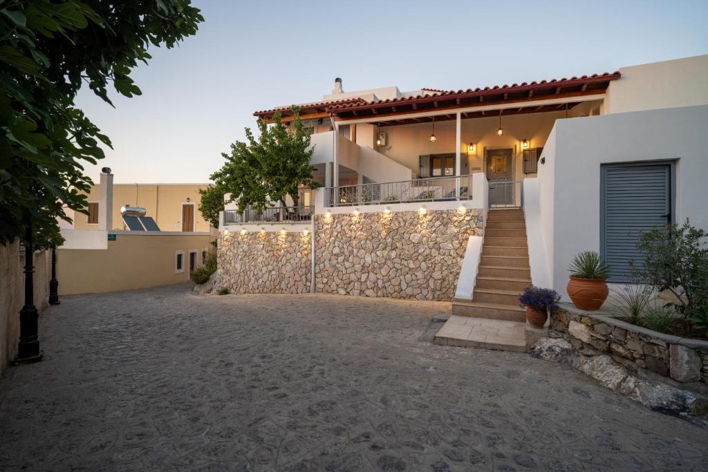 a house with a stone wall and a staircase at Zia Village Miro in Lagoúdi Zía