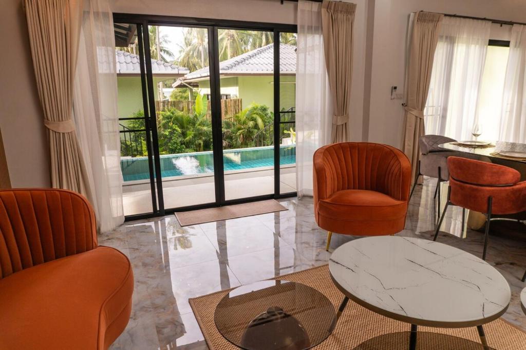 a living room with chairs and a table and a pool at Luxury Villa with Private Pool, Srithanu in Ko Kong Nui