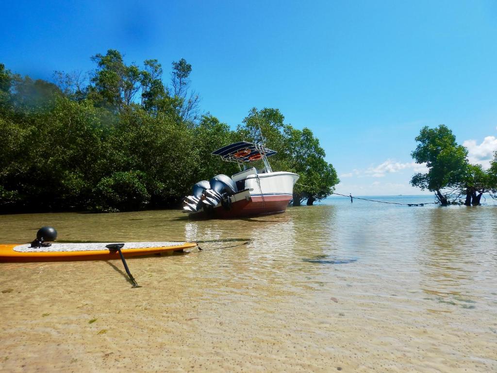 a boat and a kayak on a beach in the water at Ecoresort Sumba Dream in Rindi