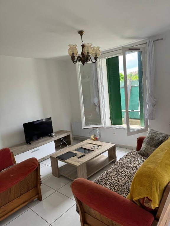 a living room with a couch and a table at Ground-Floor Apartment With private Garden in Étampes