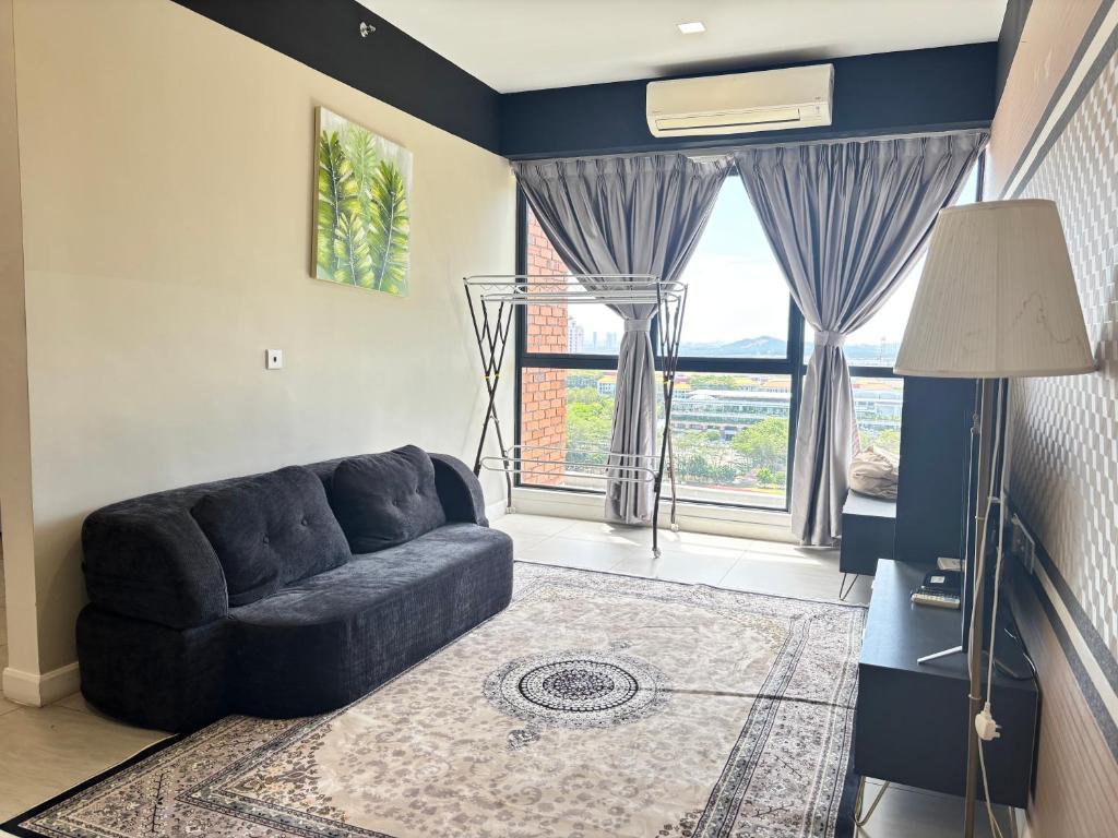 a living room with a couch and a large window at Bell Suites by Salaam Suites in Sepang