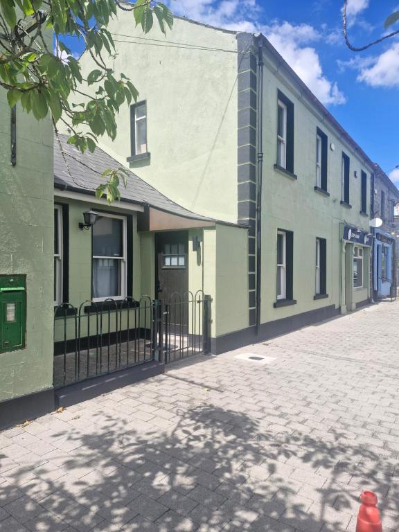 a green building with a fence next to a street at The old B&B in Killucan