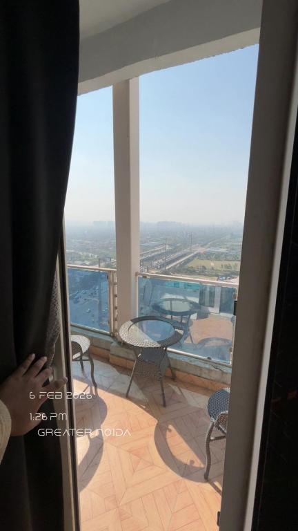 a room with a balcony with a table and chairs at Nior luxury stays in Ghaziabad