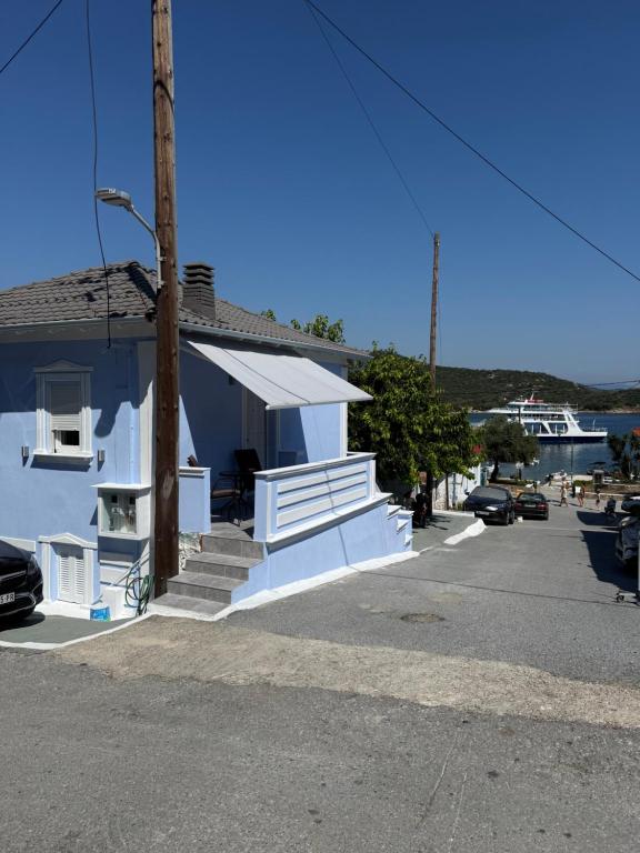 a blue building with a porch and stairs in a parking lot at Mpampis House in Ammouliani