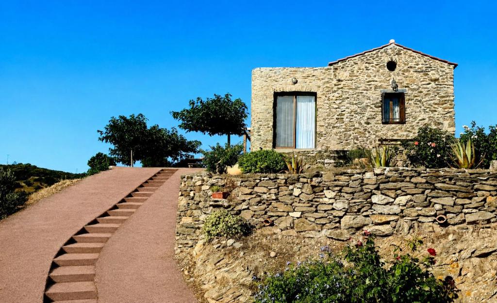 a stone house on a hill with a stone wall at Barbacane in Potamós