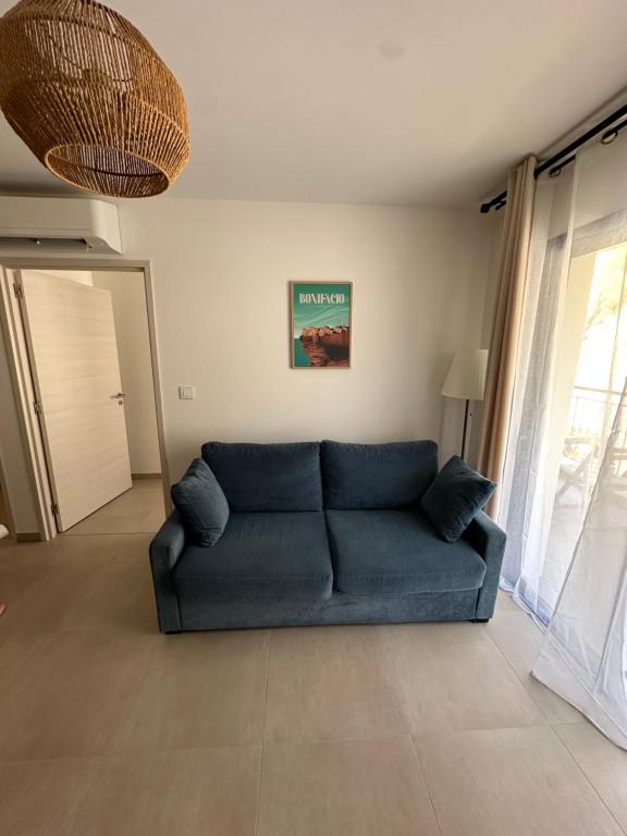 a blue couch in a living room with a window at Suarina in Porto-Vecchio