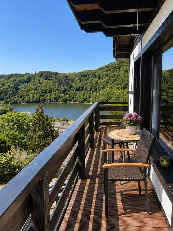 a balcony with a table and chairs and a view of a lake at Ferienhaus Sonnendeck in Simmerath