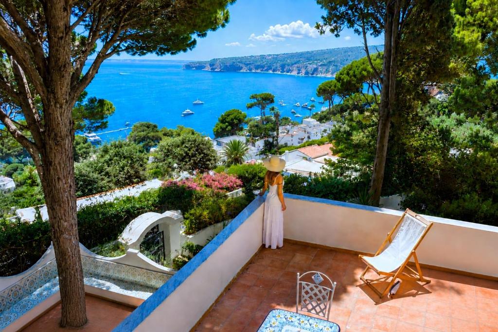 a woman standing on a balcony looking out at the ocean at Casa Schiattarella Capri in Capri
