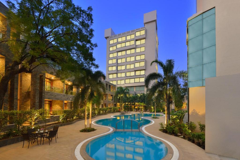 a hotel with a swimming pool in front of a building at Boulevard9, Nadiad - IHCL SeleQtions in Nadiād