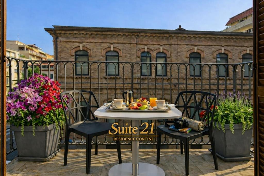 a table and chairs on a balcony with flowers at Suite 21 - Residence Contini in Falconara Marittima