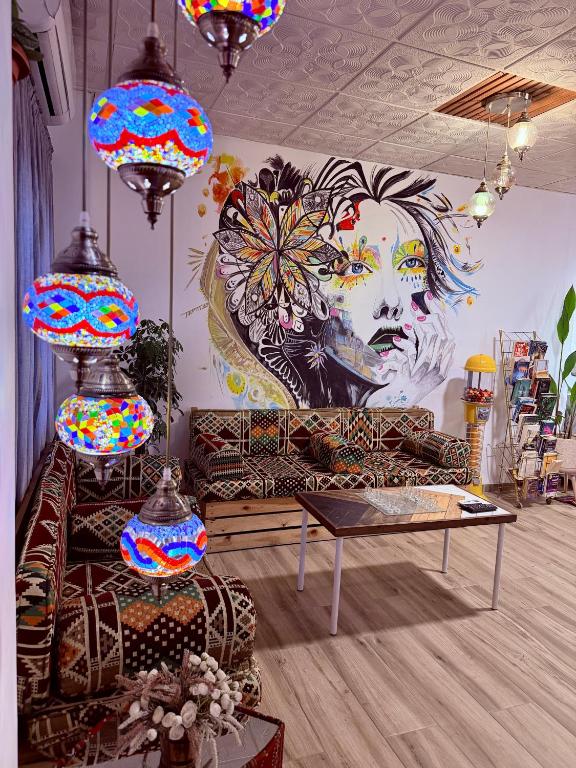 ein Wohnzimmer mit einer Couch und einem Wandgemälde in der Unterkunft The Sydney Hotel in Amman
