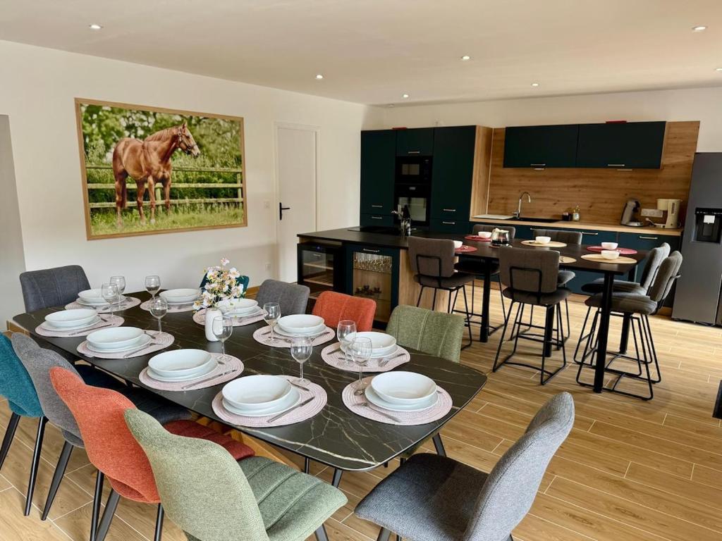 a dining room and kitchen with a table and chairs at Gite du haras in Erbrée