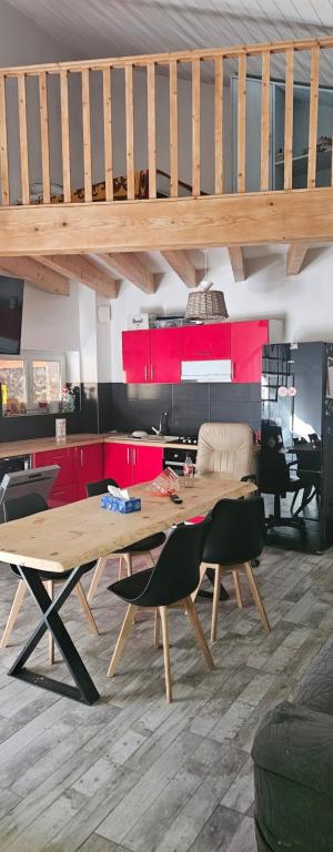 a living room with a wooden table and red cabinets at Maison de ville in Roquemaure