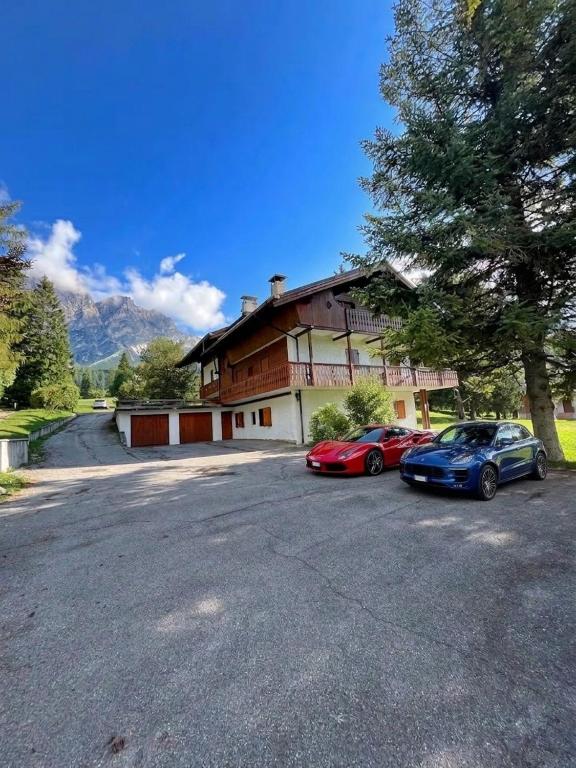 two cars parked in front of a house at Exclusive Central Chalet, 5 min Sky Slopes, Garage in Cortina dʼAmpezzo