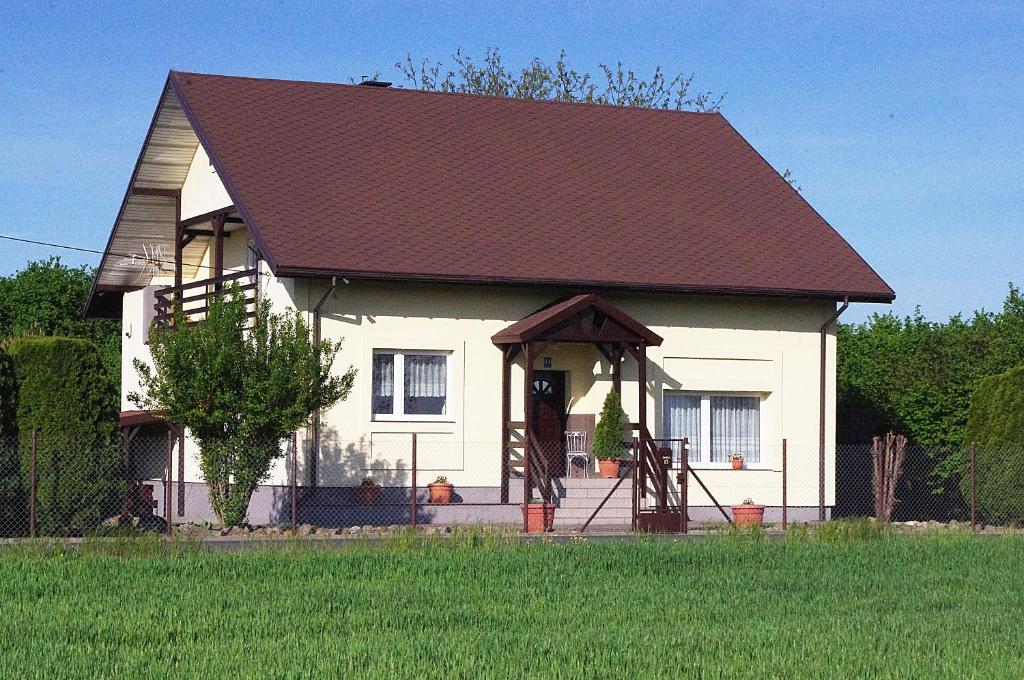 a small white house with a red roof at Laskowy Sad pokoje gościnne agroturystyka in Wieniec
