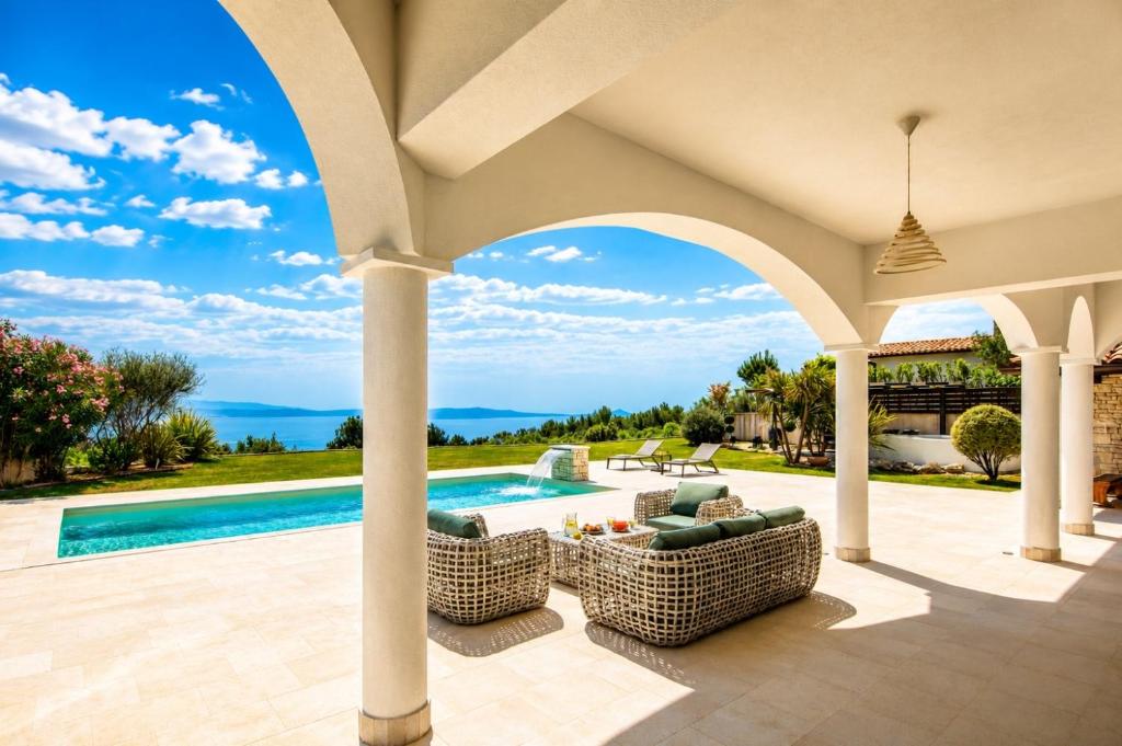 a villa with a swimming pool and a patio at Luxury Panorama Vila with amazing Seaview in Gondolici 7 km from Rabac in Labin