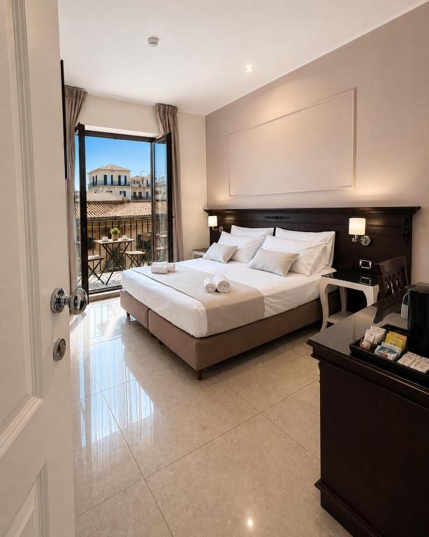 a bedroom with a large bed and a balcony at Ad Maiora Elegant Rooms in Palermo