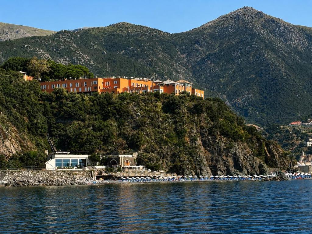 a house on top of a hill next to the water at Hotel Punta San Martino in Arenzano