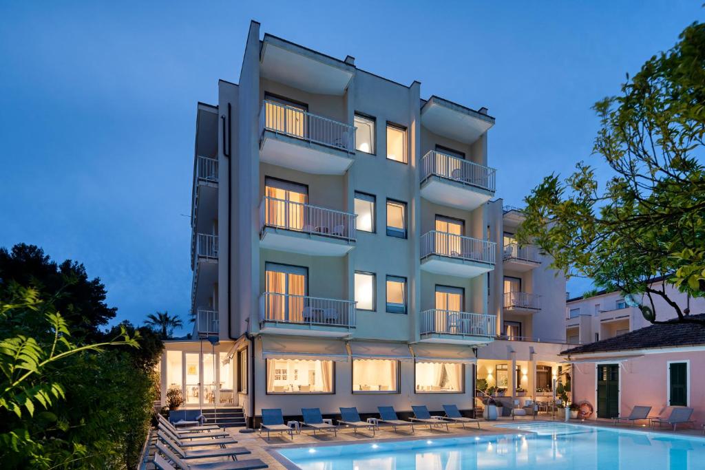 a building with a swimming pool in front of it at Hotel Splendid in Diano Marina