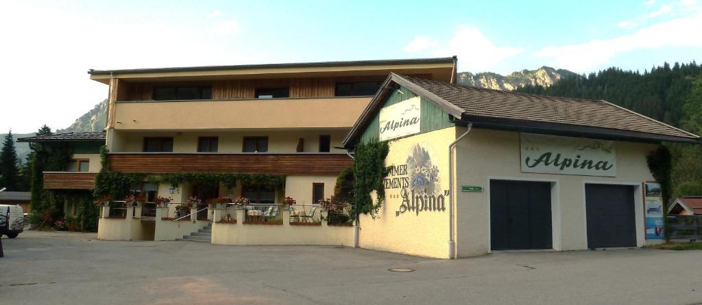 a large building with a building in a parking lot at Alpina Appartements in Haldensee