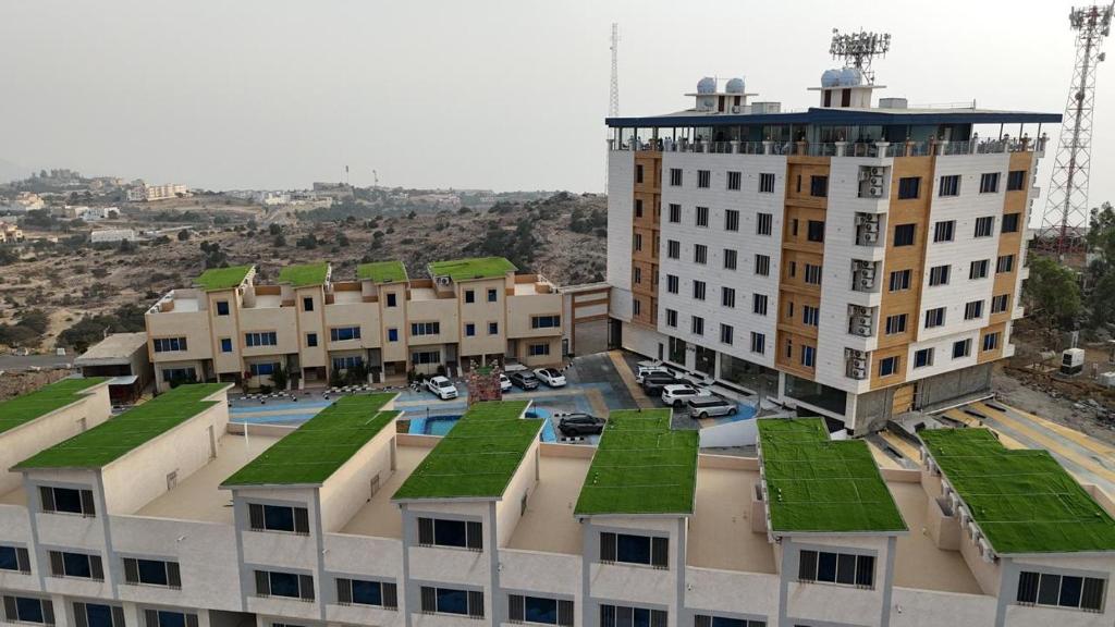 a building with green roofs on top of it at فوج فيو للفلل والشقق الفندقية in Al Namas